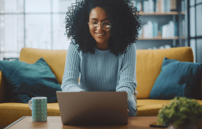 Woman sitting on couch using her laptop