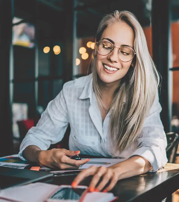 Woman sitting at a table browsing on her phone